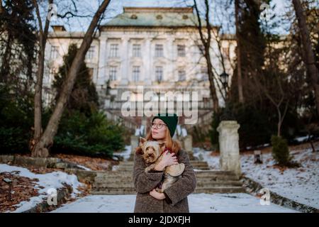 Frau mit Yorkshire Terrier, die vor dem Gebäude steht Stockfoto