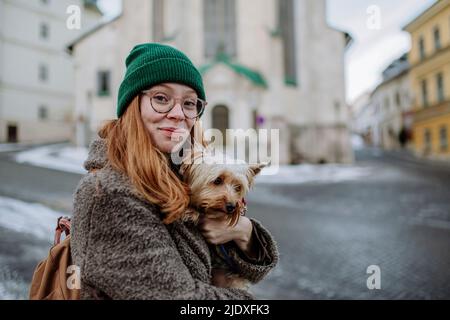 Lächelnde Frau mit Yorkshire Terrier in der Stadt Stockfoto