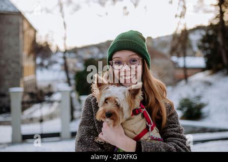 Glücklich Rotschopf Frau trägt Strickmütze trägt Yorkshire Terrier Stockfoto