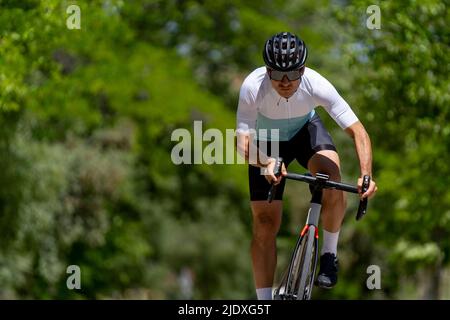 Engagierter, reifer Sportler, der an sonnigen Tagen Fahrrad fährt Stockfoto