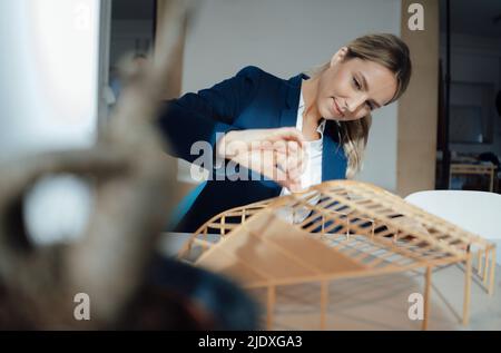 Geschäftsfrau analysiert Blattform Modell am Schreibtisch Stockfoto