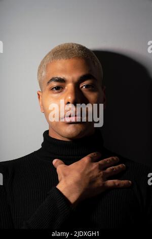 Junger Mann mit leerem Ausdruck vor grauem Hintergrund Stockfoto