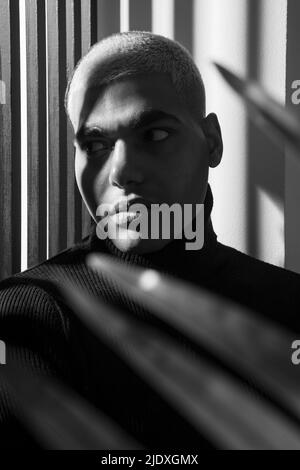 Ernsthafter Mann mit kurzen Haaren vor der Wand Stockfoto