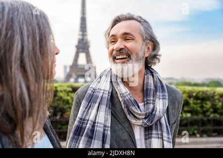 Glücklicher reifer Mann, der die Frau vor dem Eiffelturm, Paris, Frankreich, ansieht Stockfoto