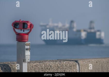 Deutschland, Schleswig-Holstein, Lübeck, Fähre verlässt Nordermole mit münzbetriebenen Ferngläsern im Vordergrund Stockfoto