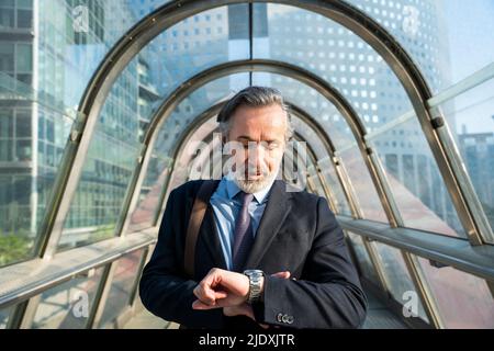 Reifer Geschäftsmann, der Zeit auf dem Steg nachgeht Stockfoto