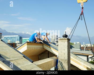 Arbeiter auf der Baustelle, die auf dem Dach arbeiten Stockfoto