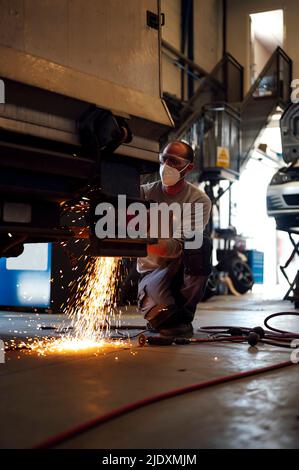 Mechaniker mit Arbeitsschutzkleidung in der Garage Stockfoto