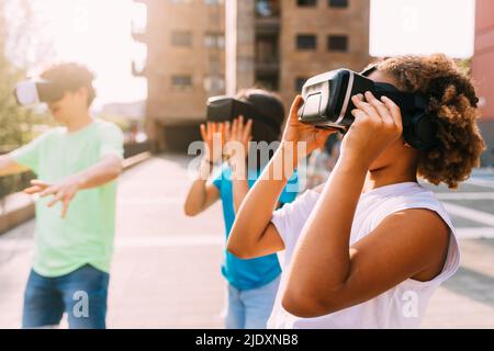 Freunde tragen Virtual-Reality-Simulator an sonnigen Tag Stockfoto