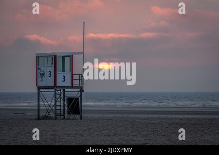 Rettungsschwimmerhütte am leeren Strand bei Sonnenuntergang Stockfoto