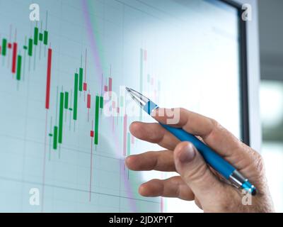 Reifer Trader, der den Aktienkurs am Computer im Büro analysiert Stockfoto