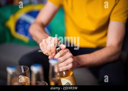 Menschenhände beim Öffnen der Bierflasche Stockfoto