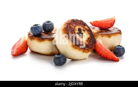 Leckere Hüttenkäse-Pfannkuchen und Beeren auf weißem Hintergrund Stockfoto