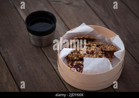 Tee mit Keksen auf einem Holztisch im Wald Stockfoto