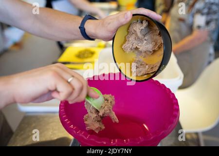 Der Prozess der Herstellung von Rochenbrot. Sauerteig wird in den Mischbehälter gegeben. Vorderansicht. Stockfoto