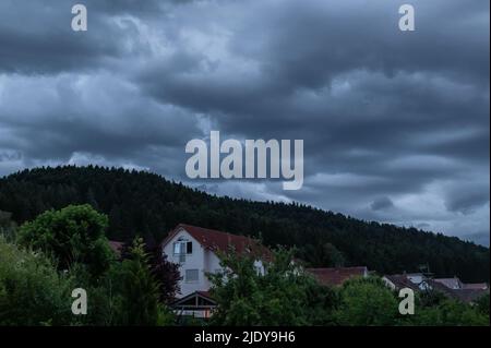 Rottweil, Deutschland. 23.. Juni 2022. Dunkle Wolken sammeln sich über einem Wohngebiet in der Nähe von Rottweil. Kredit: Silas Stein/dpa/Alamy Live Nachrichten Stockfoto