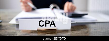 CPA-Namen auf dem Schreibtisch Platte mit der Unternehmerin Analyse der Rechnung im Büro Stockfoto