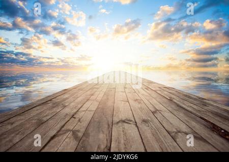 Alte hölzerne Anlegestelle am kleinen Fluss mit dramatischem Sonnenaufgang, Himmel und Wolken. Lebendige Farben. Stockfoto