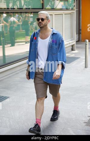 MAILAND, ITALIEN - 18. JUNI 2022: Mann mit blauem Denim-Hemd und braunen Shorts vor der Emporio Armani Fashion Show, Mailand Fashion Week Street Style Stockfoto