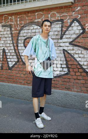 MAILAND, ITALIEN - 18. JUNI 2022: Mann mit türkisfarbenem T-Shirt und schwarzen Shorts vor der Fendi-Modenschau im Street-Style der Milan Fashion Week Stockfoto