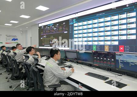 YANTAI, CHINA - 24. JUNI 2022 - Mitarbeiter überwachen den Betrieb von Windenergieanlagen im Hauptkontrollraum der staatlichen Power Investment Corpora Stockfoto