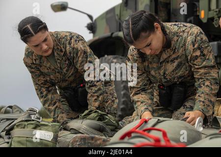 8. Juni 2022 - dh Shima, Okinawa, Japan - U.S. Marine Corps CPL. Tais Guzman, links, und CPL. Reina Martinez, beide Fallschirmspringer mit 3. Landing Support Bataillon, Combat Logistics Regiment 3, 3. Marine Logistics Group, bereiten ihre Ausrüstung für eine Luftlieferung Übung in IE Shima, Okinawa, Japan, 8. Juni 2022 vor. Ziel der Übung war es, die Qualifikation für Training und Bereitschaft zu erhalten sowie eine High Mobility Artillery Rocket System-Munitionsnachversorgung über Luftlieferung zu simulieren. 3. MLG mit Sitz in Okinawa, Japan, ist eine nach vorne eingesetzte Kampfeinheit, die als III Marine Expedi dient Stockfoto