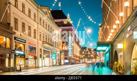 Helsinki, Finnland. Nacht der Aleksanterinkatu Straße mit Eisenbahn in Kluuvi erhalten Bezirk in Abend Weihnachten neues Jahr festliche Beleuchtung. Stockfoto