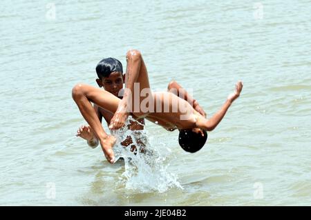 Neu Delhi, Neu Delhi, Indien. 24.. Juni 2022. East Delhi India:Schüler führen während des Sommerurlaubs in einem Wasserteich in der sengenden Hitze von Delh, Ost-Delhi, am Freitag Jumping Stunts durch (Bild: © Ravi Batra/ZUMA Press Wire) Stockfoto