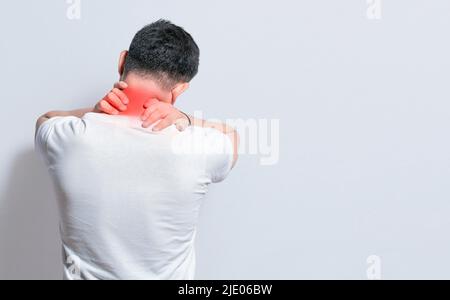 Nahaufnahme der Person mit Schulter- und Nackenproblemen, wund Mann berührt seine Schulter auf isoliertem Hintergrund, Lendenwirbelsäule und muskuläre Probleme Konzept Stockfoto