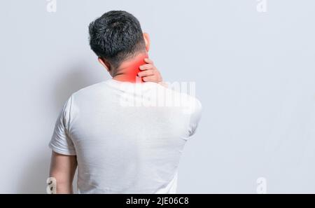 Nahaufnahme der Person mit Schulter- und Nackenproblemen, wund Mann berührt seine Schulter auf isoliertem Hintergrund, Lendenwirbelsäule und muskuläre Probleme Konzept Stockfoto