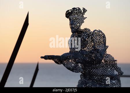 Lebensgroße skulpturale Figur im D-Day 75 Garden in Arromanches-les-Bains, Frankreich bei Sonnenuntergang. Die Installation wurde zuerst von John Everiss für erstellt Stockfoto