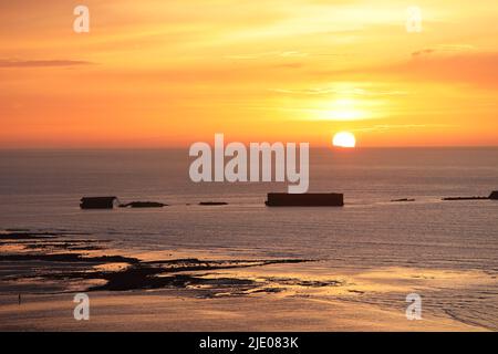 Sonnenuntergang über den Überresten des Mulberry Harbour von WW2 am Gold Beach, Arromanches-les-Bains, Normandie, Frankreich Stockfoto