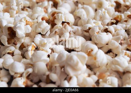 Haufen von köstlichem Popcorn auf weißem Hintergrund isoliert. Verstreute Popcorn Textur Hintergrund. Selektiver Fokus. Stockfoto