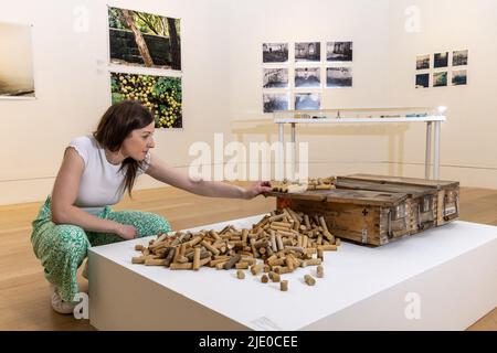 Edinburgh, Großbritannien. 24. Juni 2022 im Bild: Ein Mitglied des RSA-Personals brachte den letzten Schliff an Wunded Reliquary I von Audrey Grant, das über 500 Jesmonit- und Eisenpulvergeschossgewehrpatronen umfasst, die während ihres Aufenthalts in Cromarty gefunden wurden. Die Royal Scottish Academy präsentiert neue Werkgruppen von acht Künstlern, die von RSA Residencies for Scotland unterstützt werden, deren Praktiken alle eine starke Verbindung zur Landschaft aufweisen. Kredit: Rich Dyson/Alamy Live Nachrichten Stockfoto