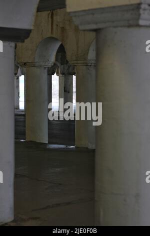 Eine Kolonnade aus Säulen in der Innenstadt, die eine Brücke über dem Hotel hält. Stockfoto