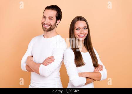 Foto von ziemlich jungen braunen Frisur Paar gekreuzte Palmen tragen weißes Outfit isoliert auf beige Farbe Hintergrund Stockfoto