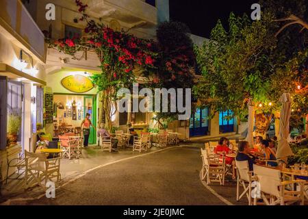 Architektonische Gebäude mit Menschen, die in den Straßen des Dorfes Chora in der Nacht zu Fuß. Stadtfotografie des malerischen Dorfes Chora in Kythera ist Stockfoto
