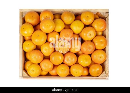 Ansicht von oben einer Holzkiste mit vielen Mandarinen und geschälten Segmenten. Stockfoto