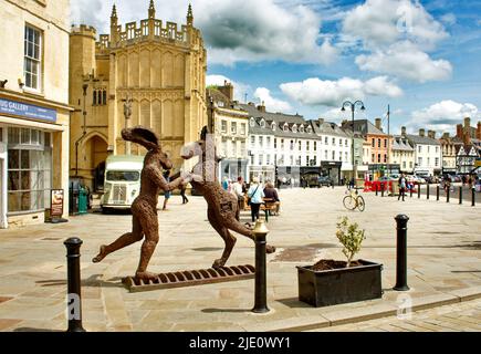 CIRENCESTER STADT GLOUCESTERSHIRE ENGLAND MARKTPLATZ MIT SKULPTUR HASE MIT HUND UND BLICK AUF DYER STREET Stockfoto