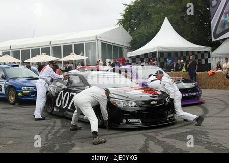 Goodwood, West Sussex, Großbritannien 24.. Juni 2022. Freiwillige Marschalls unterstützen einen Nascar beim Goodwood Festival of Speed – ‘The Innovators – Masterminds of Motorsports’, in Goodwood, West Sussex, Großbritannien. © Malcolm Greig/Alamy Live News Stockfoto