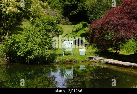 Blassgrüner Stuhl neben einem Teich Chartwell Landhaus und Residenz von Winston Churchill Westerham Kent England Großbritannien Stockfoto