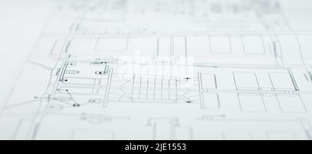 Alle planos de arquitectura enrollados y abiertos sobre una mesa Stockfoto