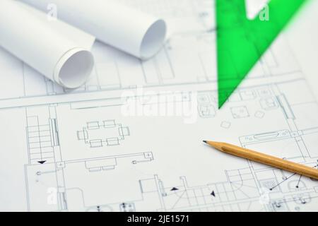 Planos de arquitectura enrollados y abiertos sobre una mesa Stockfoto