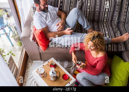Blick über das Erwachsene Paar zu Hause, das gemeinsam frühstücken kann. Konzept des realen Lebens für Mann und Frau im mittleren Alter. Apartment mit Blick von oben Stockfoto