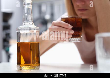 Betrunkene depressive Alkoholikerin, die zu Hause allein Whisky trinkt Stockfoto