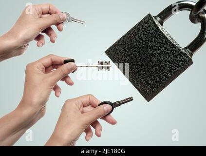 Drei weibliche Hände mit unterschiedlichen Schlüsseln versuchen, das Schloss zu öffnen. Konzept von Diebstahl, Täuschung und Hacking Stockfoto