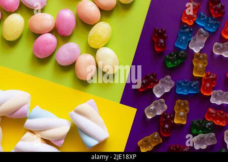 Flache Laie von Sümpfen in der Nähe von Süßigkeiten und Jelly Bears auf farbenfroher Oberfläche Stockfoto