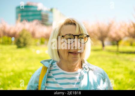 Nahaufnahme Porträt der blonden 50s Frau tragen Brille im Vergnügungspark. Stockfoto