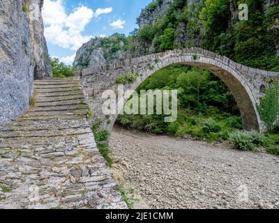 Die Brücke von Kokoros oder Noutsos wölbt sich anmutig über das je nach Saison trockene Flussbett in der oberen Vikos-Schlucht in Zagori Griechenland Stockfoto