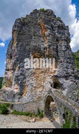 Die Brücke von Kokoros oder Noutsos wölbt sich anmutig über das je nach Saison trockene Flussbett in der oberen Vikos-Schlucht in Zagori Griechenland Stockfoto